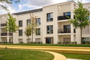 Freiham Münih Bavyera 'daki Modern Mimari: Geometrik cepheli Minimalist Bina, Büyük Pencereler ve Bulutlu Gök Altındaki Küçük Ağaç. Yüksek kalite fotoğraf