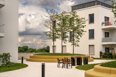 Freiham Münih Bavyera 'daki Modern Mimari: Geometrik cepheli Minimalist Bina, Büyük Pencereler ve Bulutlu Gök Altındaki Küçük Ağaç. Yüksek kalite fotoğraf