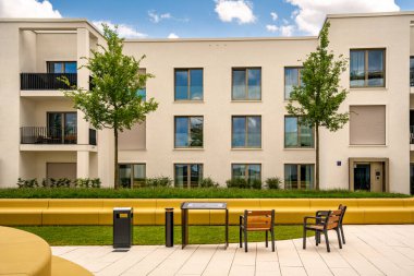 Freiham Münih Bavyera 'daki Modern Mimari: Geometrik cepheli Minimalist Bina, Büyük Pencereler ve Bulutlu Gök Altındaki Küçük Ağaç. Yüksek kalite fotoğraf