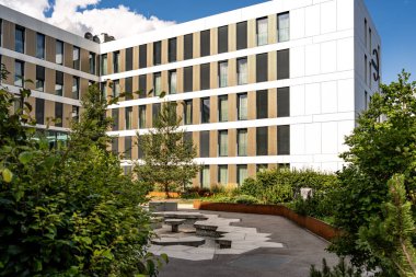 Freiham Münih Bavyera 'daki Modern Mimari: Geometrik cepheli Minimalist Bina, Büyük Pencereler ve Bulutlu Gök Altındaki Küçük Ağaç. Yüksek kalite fotoğraf