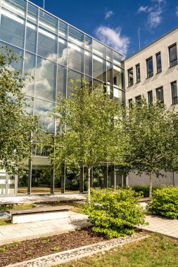 Freiham Münih Bavyera 'daki Modern Mimari: Geometrik cepheli Minimalist Bina, Büyük Pencereler ve Bulutlu Gök Altındaki Küçük Ağaç. Yüksek kalite fotoğraf