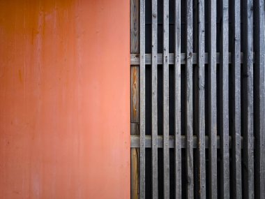 Portakal Duvarı ve Yıpranmış Tahta Çizgilerin Kontrastı ile Minimalist Mimari Desen: Soyut Şehir Arkaplanı Renklendirme Dokuları ve Geometri. Yüksek kalite fotoğraf