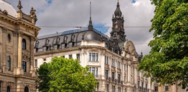 Münih 'teki Barok Mimari: Heykel Yüzlü Süslü Tarihi Bina, Kemerli Pencereler, Dekoratif Sütunlar ve Mavi Gökyüzü Altında Bulutlu Taş Detayları. Yüksek kalite fotoğraf