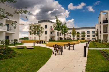 Freiham Münih Bavyera 'daki Modern Mimari: Geometrik cepheli Minimalist Bina, Büyük Pencereler ve Bulutlu Gök Altındaki Küçük Ağaç. Yüksek kalite fotoğraf