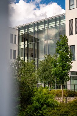 Freiham Münih Bavyera 'daki Modern Mimari: Geometrik cepheli Minimalist Bina, Büyük Pencereler ve Bulutlu Gök Altındaki Küçük Ağaç. Yüksek kalite fotoğraf