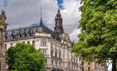 Münih 'teki Barok Mimari: Heykel Yüzlü Süslü Tarihi Bina, Kemerli Pencereler, Dekoratif Sütunlar ve Mavi Gökyüzü Altında Bulutlu Taş Detayları. Yüksek kalite fotoğraf