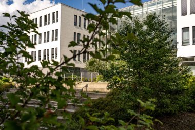 Freiham Münih Bavyera 'daki Modern Mimari: Geometrik cepheli Minimalist Bina, Büyük Pencereler ve Bulutlu Gök Altındaki Küçük Ağaç. Yüksek kalite fotoğraf