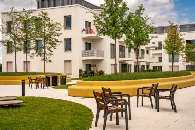 Freiham Münih Bavyera 'daki Modern Mimari: Geometrik cepheli Minimalist Bina, Büyük Pencereler ve Bulutlu Gök Altındaki Küçük Ağaç. Yüksek kalite fotoğraf