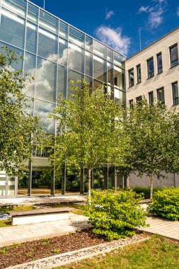 Freiham Münih Bavyera 'daki Modern Mimari: Geometrik cepheli Minimalist Bina, Büyük Pencereler ve Bulutlu Gök Altındaki Küçük Ağaç. Yüksek kalite fotoğraf