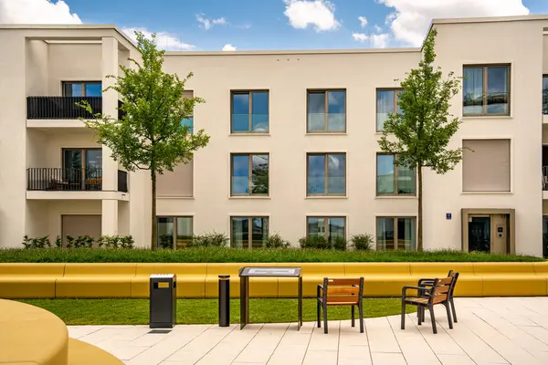 Freiham Münih Bavyera 'daki Modern Mimari: Geometrik cepheli Minimalist Bina, Büyük Pencereler ve Bulutlu Gök Altındaki Küçük Ağaç. Yüksek kalite fotoğraf