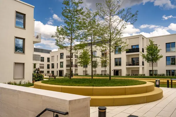 Freiham Münih Bavyera 'daki Modern Mimari: Geometrik cepheli Minimalist Bina, Büyük Pencereler ve Bulutlu Gök Altındaki Küçük Ağaç. Yüksek kalite fotoğraf