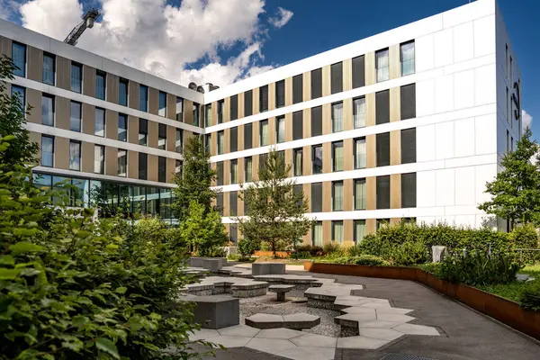 Freiham Münih Bavyera 'daki Modern Mimari: Geometrik cepheli Minimalist Bina, Büyük Pencereler ve Bulutlu Gök Altındaki Küçük Ağaç. Yüksek kalite fotoğraf