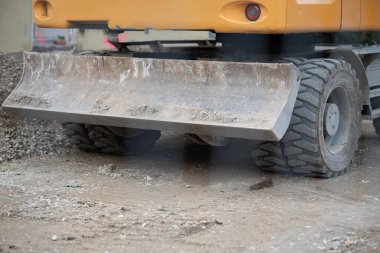 Sarı İnşaat Makinesine Eklenmiş Ağır Kazı Kovası Kirli Zemin ve Çalışma Alanındaki Yeşillik. Yüksek kalite fotoğraf