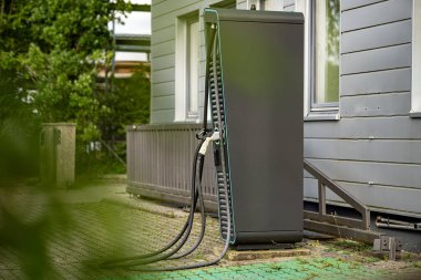 Çift bağlantıları olan elektrikli araç şarj istasyonu: Modern EV güç tedarik kablolarına yakın çekim ve şehir merkezinde üzerinde yeşil LED çizgileri olan prizler. Yüksek kalite fotoğraf