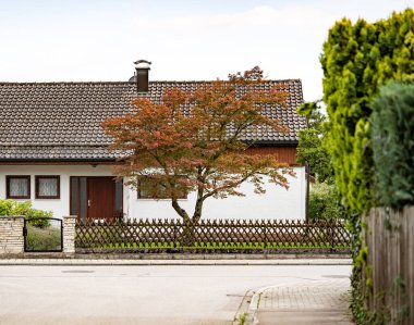 Kahverengi çatılı ve ön bahçesinde sonbahar ağacı olan ahşap çitin yanında Beyaz Saray 'ın olduğu sessiz bir yerleşim yeri. Yüksek kalite fotoğraf