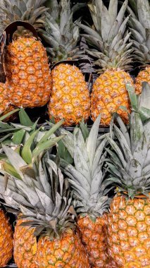 Top-down view of a neatly arranged pineapple display in a supermarket. clipart