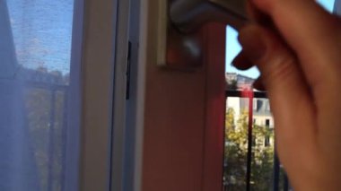 Kadının eli pencereyi Montmartre tepelerinin manzarasıyla kapatıyor. 