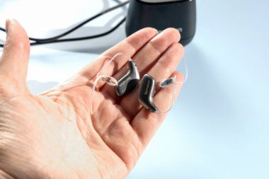 Kadın eli modern işitme cihazını tutuyor.