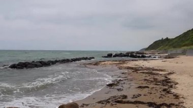 Kıyı şeridi kayalık dalgalı ve mavi gökyüzü bulutlu