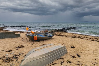Filikalar kıyıya vurur, dalgalar hafifçe vurur, gökyüzü ışıkla parlar..