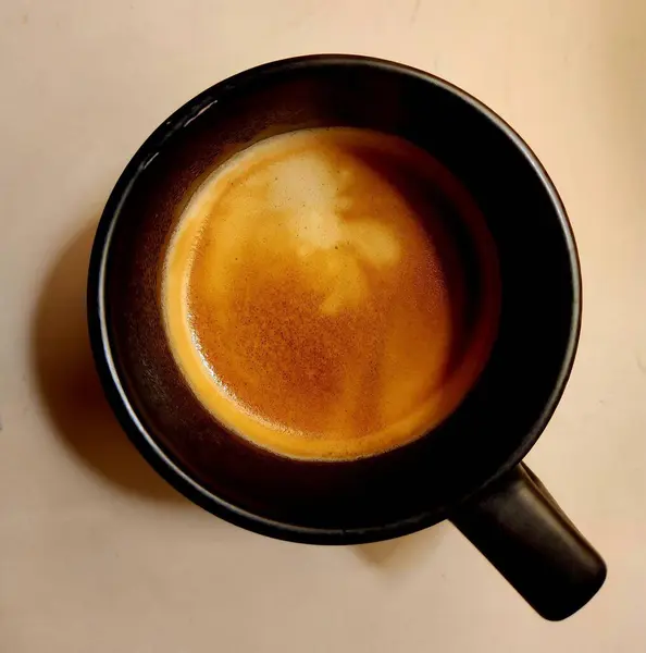 Yukarıdan köpüklü bir fincan kahve.
