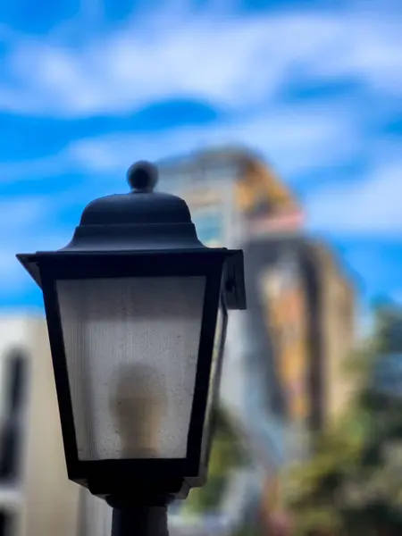 Güneşli bir günde arka planda bulanık bir görüntü ile eski tarz sokak lambası