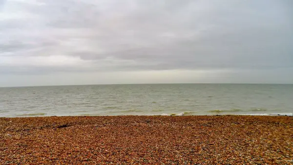Bulutlu bir günde deniz manzaralı çakıl taşı plajı