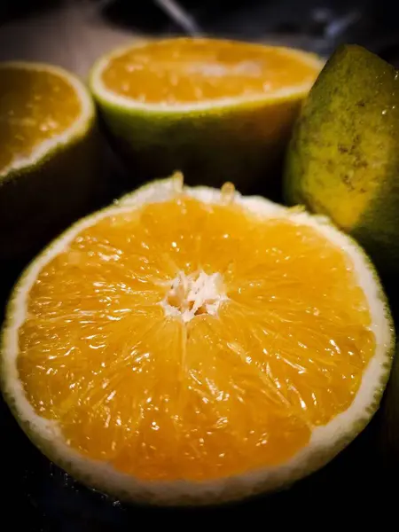 Taze, sulu, olgunlaşmış portakal meyvesinin canlı yakın plan görüntüsü. Parlak, sulu, davetkar etini ortaya çıkarıyor. Dokunun ayrıntıları meyvenin tazeliğini vurgular..