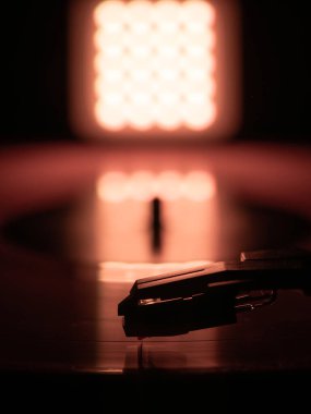  Arka planda ışık olan bir vinil plakta yakın çekim kayıt iğnesi.