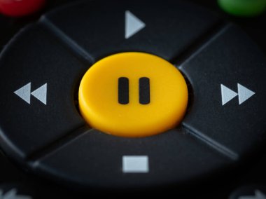 TV kumandasında büyük sarı bir durdurma düğmesi.