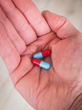 Avucunun içinde bir çift mavi ve kırmızı hap - ilacını al