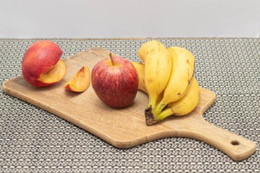 Beyaz arka planda muz, elma ve portakal meyvesi