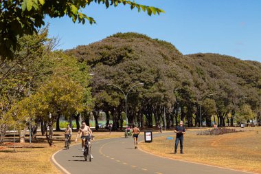 Parkta bisiklete binen insanlar