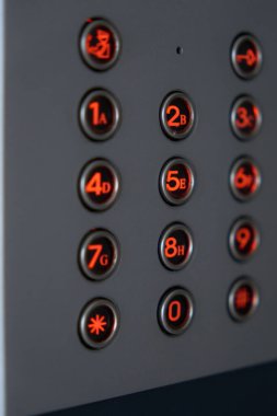 Kullanıcı kolaylığı için çeşitli zemin seçim düğmelerini gösteren parlak ve aydınlık bir asansör tuş takımı.