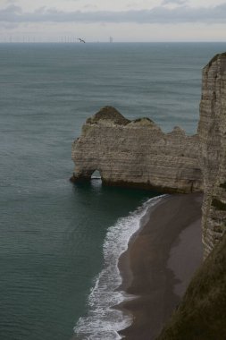 Etretat kayalıkları yumuşak kış renkleriyle yıkandı. Huzurlu bir deniz ve yumuşak bulutlarla kaplı..