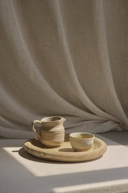 Elsiz kil çay fincanı ve geleneksel Ukrayna gletchyk 'ine benzer büyüklükte küçük bir sürahi killi fincan tahta bir tepsiye konur. Tepsi yumuşak pastelle kaplanmış bir masanın üzerine konmuş.