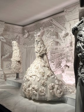 Nefes kesici ve çarpıcı bir görüntü, sanatsal açıdan detaylı bir şekilde hazırlanmış zarif beyaz elbiseler sergiliyor.