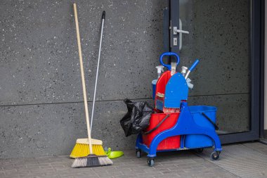 Modern beton bir duvara karşı çeşitli profesyonel temizlik ürünleri ve aletlerle tramvayı temizlemek. Ticari temizlik, hijyen bakımı ve temizlik malzemeleri.
