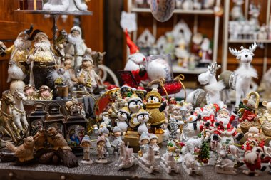 Festive Christmas figurines and decorations on display at holiday market. Concept of traditional seasonal ornaments, holiday shopping clipart