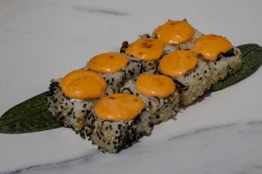 Yeşil yapraklı baharatlı mayonezli suşi ruloları, beyaz tabakta servis ediliyor. Japon mutfağı, geleneksel yemekler ve gurme yemekleri.