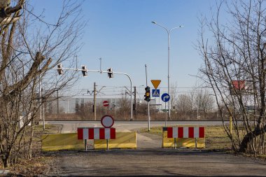 Yol barikatlarla, trafik ışıklarıyla ve tren yolu yakınlarındaki bir kavşakta trafik ışıklarıyla kapalı. Yol kapatma, kısıtlı erişim, sapma, altyapı, ulaşım ve şehir güvenliği