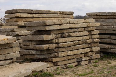 Bulutlu gökyüzünün altındaki inşaat alanında kullanılmış beton levhalar. Sürdürülebilir mimari, çevre dostu kentsel kalkınma, geri dönüşüm yapı malzemeleri ve inşaat atıklarının azaltılması