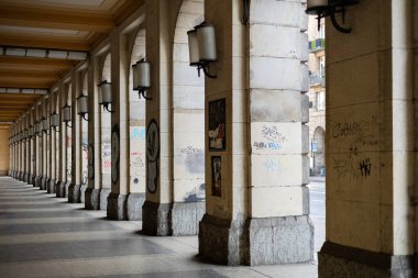 Wroclaw, Poland- 12 Nisan 2025: Simetrik taş sütunlar ve Wroclaw şehir merkezinde duvar yazısıyla kaplı fenerlerle birlikte tarihi sütun