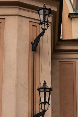 Tarihi bir binanın ön cephesine astar ve mimari detaylarla döşenmiş dekoratif zincirlerle döşenmiş klasik demirden sokak fenerleri. Klasik Avrupa şehir mimarisi ve mirası