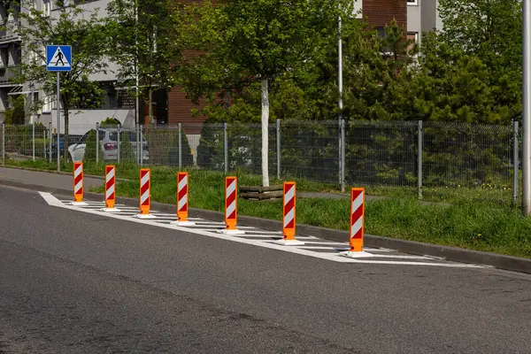 Şehir caddesinde yaya geçidi yakınlarında parlak kırmızı ve beyaz yansıtıcı yol güvenliği var. Modern ortamlarda trafik kontrolü, kamu güvenliği ve şehir altyapısı