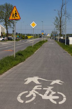 Yaya ve bisiklet yolu banliyö yolu boyunca açık güvenlik işaretleri ve trafik işaretleriyle. Yol güvenliği, çocuk koruması, paylaşılan yollar ve kentsel altyapı planlaması
