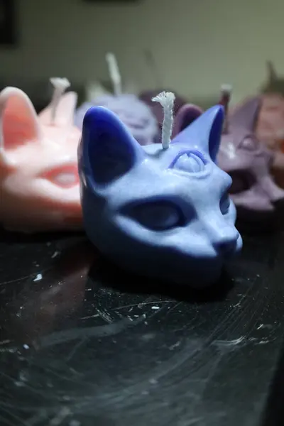 Alnında üçüncü bir göz olan karmaşık şekilli kedi şekilli mumlar.