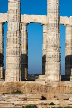 Sounio, Yunanistan - 19 Ocak 2025 Poseidon Tapınağı 'nın görkemli kalıntıları derin mavi bir gökyüzüne karşı durmaktadır.