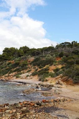 Kristal berraklığında turkuaz suları ve yoğun Akdeniz bitkileriyle çevrili engebeli uçurumları olan tenha bir koy.