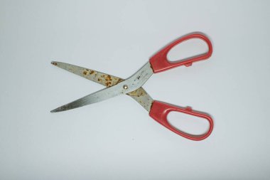 Beyaz arkaplanda izole edilmiş kırmızı saplı bir makasın yakın çekimi